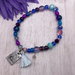 peace bracelet, light blue tassel, purple and blue beads, stretch bracelet, handmade, new