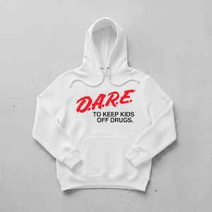 May include: White hoodie with a front pocket and drawstring hood. The red text on the front reads "D.A.R.E. TO KEEP KIDS OFF DRUGS." The hoodie is made of a soft material and is suitable for casual wear.
