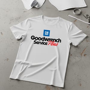 May include: A white ceramic mug with a black handle and the text "But First, Coffee" in a black, bold font. The mug is on a white surface.