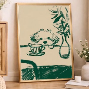 May include: A framed art print featuring a green and beige illustration. The artwork depicts a dog resting its head on a table with a teacup and saucer. A vase with greenery is also on the table. The print has a gold frame and is leaning against a wall.