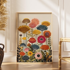 May include: A framed art print depicting colourful stylized flowers in shades of orange, pink, yellow, and blue. The artwork has a gold frame and is displayed against a neutral background. The print adds a touch of nature-inspired decor.