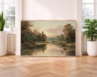 Op de afbeelding: Een ingelijst landschapsschilderij toont een rustige rivierscène met bomen en een zachte, bewolkte lucht. Het kunstwerk wordt tentoongesteld op een houten vloer, geflankeerd door potplanten en ramen, wat een serene sfeer creëert. Het schilderij is ongeveer 91 cm breed en 61 cm hoog.
