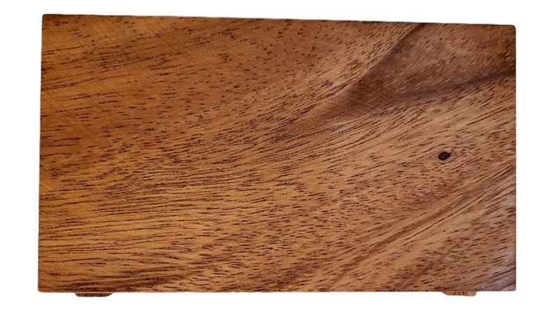 May include: A rectangular wooden box with a natural wood grain finish. The box has a light brown color and a smooth surface.
