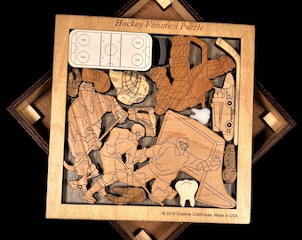 May include: A wooden Hockey Fanatics Puzzle in a square frame featuring laser-cut pieces shaped like hockey players, a rink, a goal, and teeth. The frame is inscribed with Hockey Fanatics Puzzle and 2016 Creative Crafthouse Made in USA.