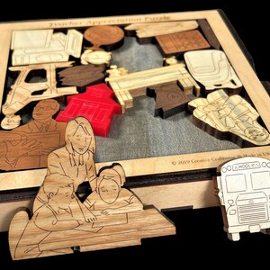 May include: Wooden teacher appreciation puzzle with a red schoolhouse, a school bus, and a teacher with students. The puzzle pieces are laser cut and fit together to create a complete picture.
