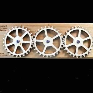 May include: A wooden Enigma II encryption machine with three rotating gears, each with a different alphabet. The gears are labeled with letters from A to Z. The machine is made in the USA by Creative Crafthouse.