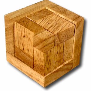 May include: A wooden puzzle cube with interlocking pieces. The cube is made of light brown wood and has a complex design with multiple layers and geometric shapes. The pieces are precisely cut and fit together to form the cube.