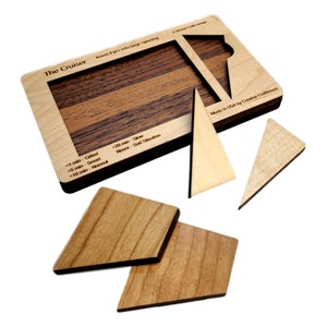 May include: The Cruiser wooden brain teaser puzzle with four pieces. The puzzle is made of light and dark wood. The puzzle is made in the USA by Creative Crafthouse. The puzzle has a difficulty rating of <1 min - Gifted, <5 min - Smart, <10 min - Normal, <20 min - Slow, Never - Sad Situation.