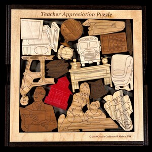 May include: A wooden teacher appreciation puzzle with a schoolhouse, a bus, a computer, a clock, books, a desk, a chair, and a teacher with students. The puzzle is made by Creative Craft House and is made in the USA.