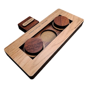 May include: Wooden brain teaser puzzle with the text "Animal Challenge - Pet Puzzle" and "Brain Teaser" on the top. The puzzle has two round wooden pieces with paw prints engraved on them.