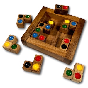 Op de afbeelding: Houten puzzelspel met kleurrijke blokjes. Elk blokje heeft vier zijden met een andere gekleurde stip: rood, geel, groen en blauw. De blokjes zijn gerangschikt in een vierkant frame.