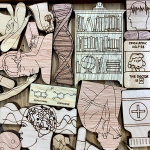 May include: Wooden puzzle with various pieces depicting a brain, DNA, a bookshelf, a person in a fetal position, a pill bottle, and a person with a thought bubble. The text "PSYCHIATRIC HELP 5&cent;" and "THE DOCTOR IS IN" are also included.
