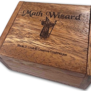 May include: Wooden box with a lid, engraved with the words "Math Wizard" and a cartoon image of a wizard. The box is made in the USA by Creative Crafthouse.