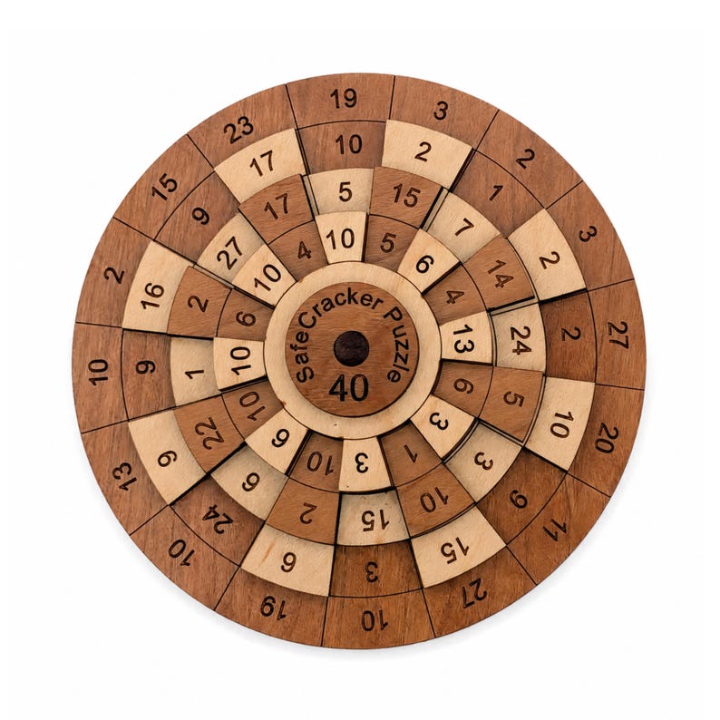 May include: A circular wooden puzzle with concentric rings featuring alternating light and dark wood segments. Each segment is printed with a black number. The center piece displays the text SafeCracker Puzzle and the number 40 in black ink.
