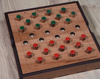 May include: A wooden checkers game board with red and green game pieces. The board has a grid pattern with the word "Checkers" at the top. The game pieces are cylindrical with a metallic base and colored tops. The board is made in the USA.