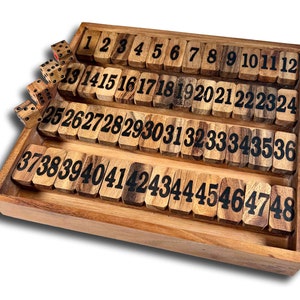 May include: A wooden game board with numbered tiles from 1 to 48. The tiles are arranged in rows and are made of light brown wood with black numbers. There are four dice on the board, two of which are red and two of which are black.