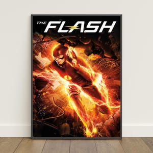May include: A framed poster featuring The Flash in a red suit surrounded by bright yellow lightning bolts and debris. The text THE FLASH is printed in large white letters at the top with a yellow lightning bolt replacing the letter A.