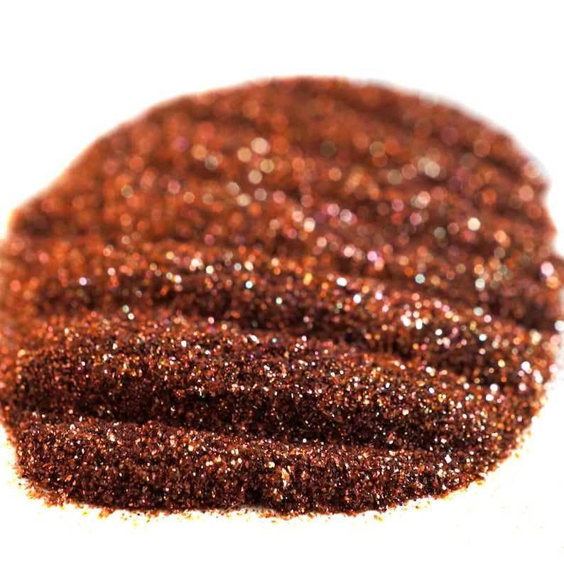 May include: A close-up of a pile of fine copper glitter with iridescent shimmer.