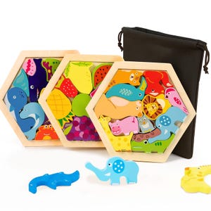 Puede incluir: Rompecabezas de madera con animales y frutas, de forma hexagonal. Los rompecabezas presentan piezas coloridas, como un delfín azul, un cangrejo rojo, un limón amarillo y uvas moradas. Se incluye una bolsa negra con cordón.