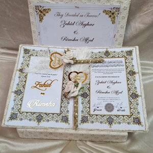 May include: A cream-coloured wedding keepsake box with a floral design. The box is open, revealing a certificate with the names Zahid Asghar and Rimsha Afzal. The text "They Decided on Forever!" is at the top.