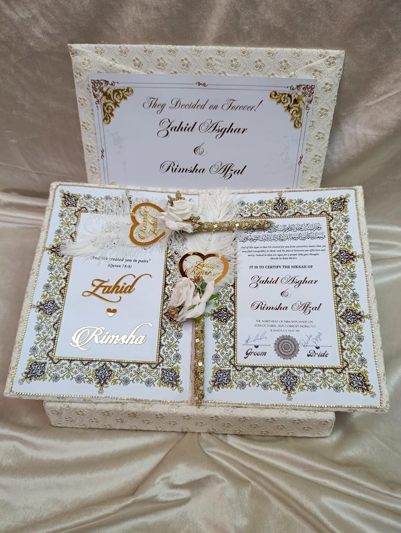 May include: A cream-coloured wedding keepsake box with a floral design. The box is open, revealing a certificate with the names Zahid Asghar and Rimsha Afzal. The text "They Decided on Forever!" is at the top.
