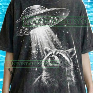 May include: A white ceramic mug with a black handle and the text "But First, Coffee" in a black, bold font. The mug is on a white surface. The mug is 10 cm tall.