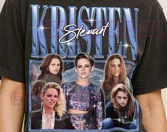 May include: Dark grey t-shirt with a graphic of actress Kristen Stewart. The design features her name in a blue, stylized font, and multiple images of her. The shirt has a vintage, distressed appearance.