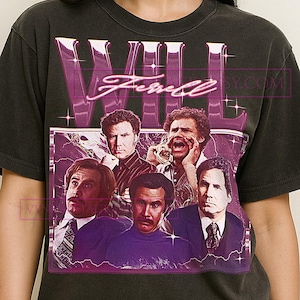 Op de afbeelding: Donkergrijs t-shirt met een paarse afbeelding met de naam "WILL FERRELL" en afbeeldingen van de acteur. Het ontwerp bevat een paars bliksemeffect en een vintage esthetiek.