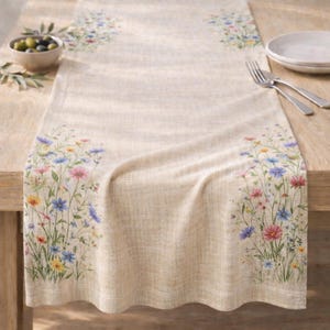 May include: A white ceramic mug with a black handle and the text "But First, Coffee" in a bold, black font. The mug is set against a blurred background, suggesting a cozy setting.