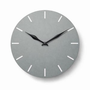 May include: A circular grey wall clock featuring white, rectangular hour markers. The clock has black hands and a minimalist design. The clock is set against a white background.