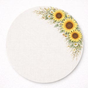 May include: A round, off-white placemat with a watercolor design of sunflowers, daisies, and greenery. The floral arrangement is in the upper right corner, featuring yellow sunflowers with brown centers and white daisies.