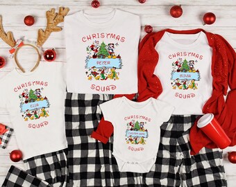 May include: White Christmas Squad t-shirts and a onesie with matching black and white plaid pajama pants. Each shirt features a cartoon graphic with the text "Christmas Squad" and a personalized name. Red accents include a long-sleeved shirt and ornaments.