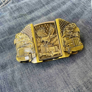 May include: A white ceramic mug with a black handle and the text "But First, Coffee" in a bold, black font. The mug is set against a blurred background, suggesting a cozy setting.