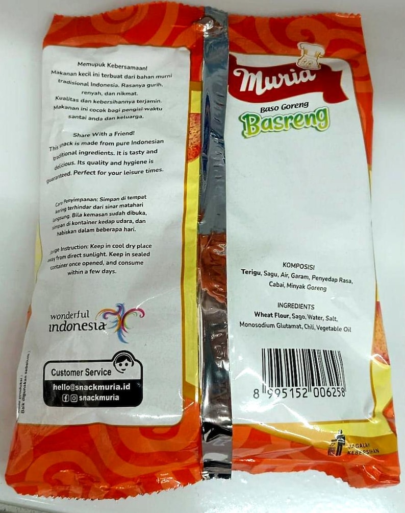 May include: A packaged snack product with the brand name "Muria Basreng" in green and white text. The packaging is primarily orange and white, with Indonesian text and ingredient information. The product is described as a traditional Indonesian snack.