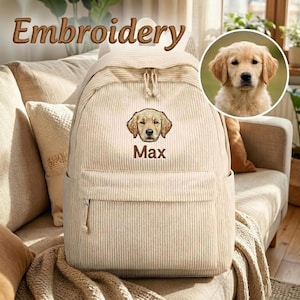 以下が含まれることがあります： ゴールデンレトリバーの顔の刺繍と茶色の糸で「Max」という名前が施されたベージュのコーデュロイ製バックパック。フロントジッパーポケット、2本のショルダーストラップ、ゴールデンレトリバーの子犬が写った円形のインセットが付いています。