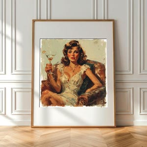 Può includere: Una stampa vintage incorniciata raffigura una donna in abito bianco seduta su una poltrona di pelle, con in mano un martini. L'opera d'arte ha un'estetica retrò, con toni caldi e un classico stile pin-up.