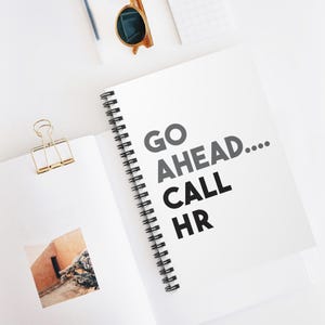 May include: A white spiral bound notebook with the text "GO AHEAD... CALL HR" in black and gray lettering.