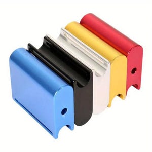 Puede incluir: Una fila de objetos metálicos coloridos en azul, negro, plateado, dorado y rojo. Cada uno tiene una ranura curva y un pequeño agujero. Los objetos están alineados, mostrando sus colores vibrantes y su diseño sencillo.