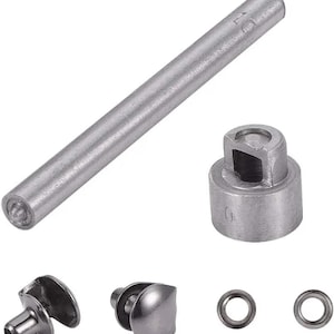 May include: A set of silver-colored metal tools and hardware components, including a long cylindrical punch, a cylindrical die with a square opening, two rivet components, and two small eyelets. The tools are designed for use in crafting or repair.