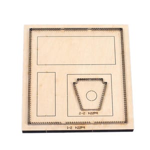 Puede incluir: Plantilla de corte de madera con varias formas, incluyendo rectángulos y una forma estilizada con un recorte circular. La plantilla tiene un borde de corte metálico alrededor de las formas. El texto "bd224 2-2" y "bd224 2-1" es visible.