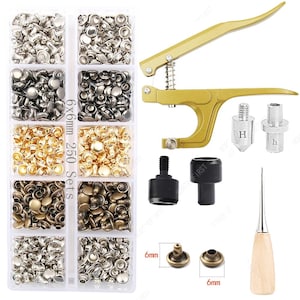 May include: A set of metal rivets in various colors, including silver, black, and gold, organized in a clear plastic container. A gold-colored rivet press, along with several tools, and a wooden-handled awl are also included. The rivets are 6x6mm.