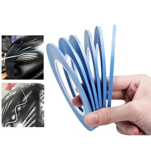 May include: A set of thin, light blue adhesive pinstriping tapes arranged in a fan shape. The tapes feature a smooth, matte finish and are designed for creating precise lines on curved surfaces, as shown in the two small inset example images.