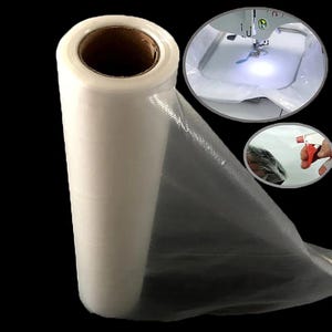May include: A roll of translucent, thin, white water-soluble embroidery stabilizer film. The roll features a cardboard core. Two circular insets show the film being used under a sewing machine needle and being sprayed with water.