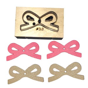 Può includere: Uno strumento di taglio in legno con un ritaglio a forma di fiocco e quattro fiocchi in pelle rosa e beige. Lo stampo ha un foro di 3,0 mm di diametro. I fiocchi in pelle sono pronti per progetti di artigianato.