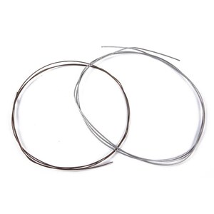 May include: Two circular coils of thin metal wire are displayed. One coil is a dark brown or bronze colour, while the other coil is a bright silver colour. Both wires are thin, flexible, and arranged in loose, overlapping circular loops.