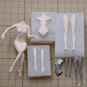 Puede incluir: Un conjunto de partes de cuerpo de muñeca lisas y pálidas que incluye una figura completa, un torso, dos brazos y dos piernas, junto con moldes de silicona para fundir estos componentes. La colección presenta piezas claras y grises.