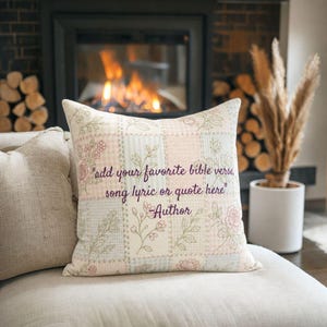 May include: Square decorative pillow with a patchwork design in pastel pink, white, and light blue. The pillow features embroidered floral accents and the text "add your favorite bible verse, song lyric or quote here" and "Author".