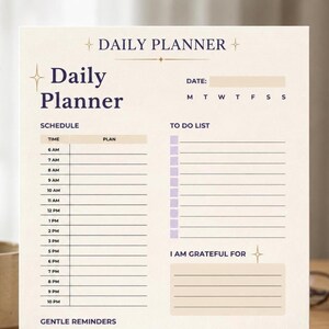 Puede incluir: Un planificador diario beige con la frase "Daily Planner" en fuente morada oscura. El planificador incluye secciones para programar, listas de tareas y gratitud. El diseño es minimalista y elegante, con un diseño limpio.