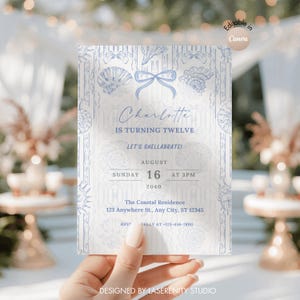 Könnte beinhalten: Eine hellblaue und weiße Einladungskarte mit Muscheldarstellungen. Die Karte lautet "Charlotte wird zwölf" und enthält Veranstaltungsdetails: 16. August um 15 Uhr und die Adresse. Das Design stammt von Laserenity Studio.