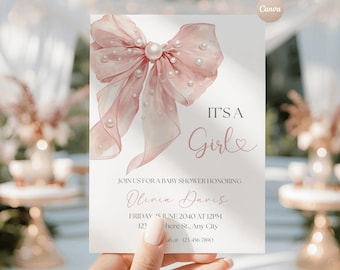 May include: A white baby shower invitation card featuring a large, sheer, light pink bow adorned with white pearls. The text reads: IT'S A Girl, JOIN US FOR A BABY SHOWER HONORING Olivia Davis, FRIDAY 15 JUNE 2040 AT 12PM, 123 Anywhere St., Any City.